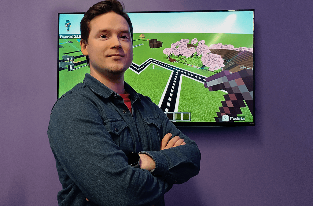 Minecraft director Niko Strawberry pictured from the front, with Minecraft screenshots in the background.