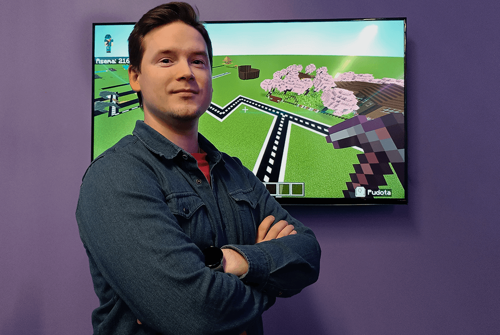 Minecraft director Niko Strawberry pictured from the front, with Minecraft screenshots in the background.