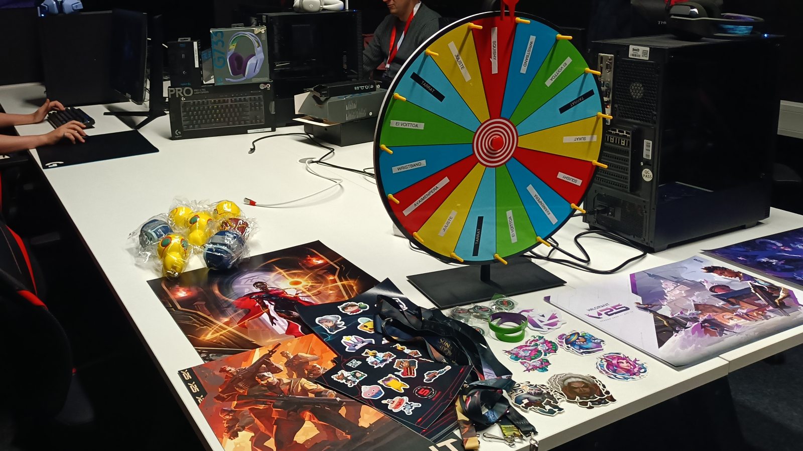 EXENin Riot Play Clubeissa käytettävä onnenpyörä ja Riot-aiheisia palkintoja, kuten tarroja, julisteita ja stressileluja.